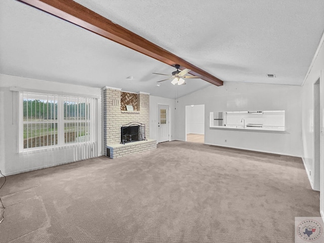 unfurnished living room with light colored carpet, a textured ceiling, vaulted ceiling with beams, and a brick fireplace