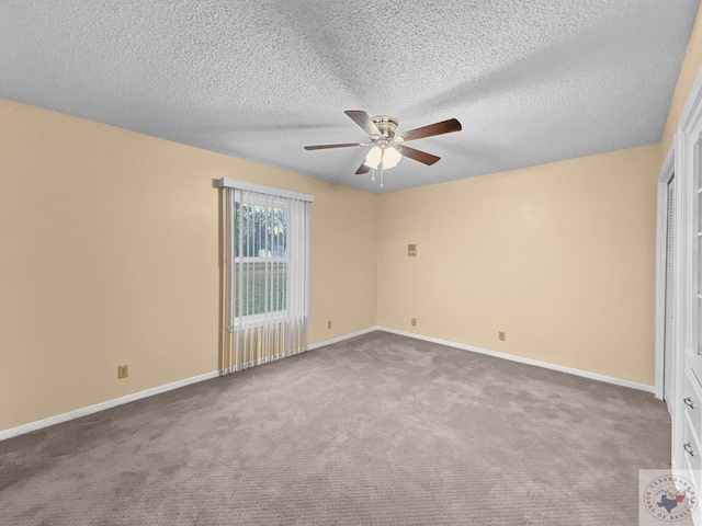 spare room featuring a textured ceiling, carpet floors, and ceiling fan