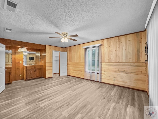 interior space featuring wood walls, hardwood / wood-style flooring, and a textured ceiling