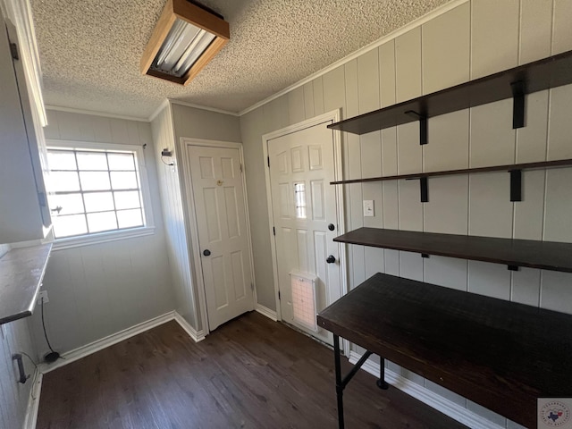 entrance foyer featuring dark wood finished floors, a textured ceiling, crown molding, and baseboards