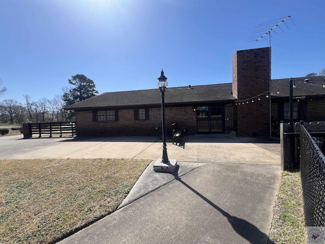 rear view of house featuring brick siding, a patio, and fence