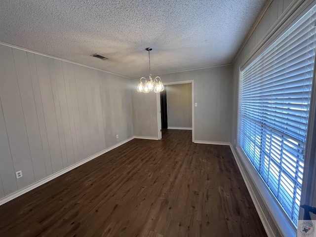 interior space featuring baseboards, a notable chandelier, dark wood-style floors, and a textured ceiling