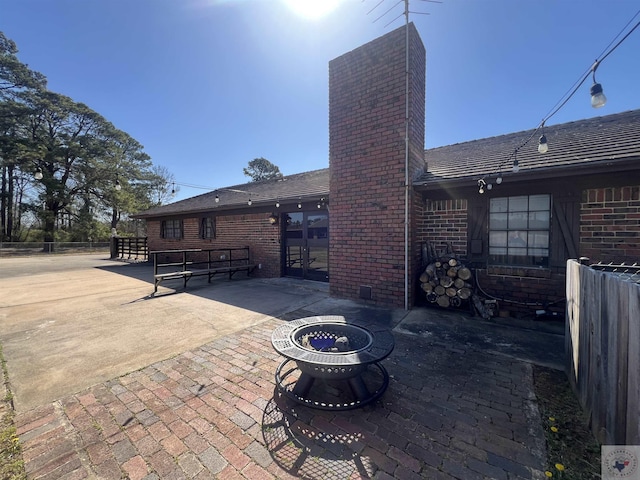 view of patio / terrace with a fire pit and fence