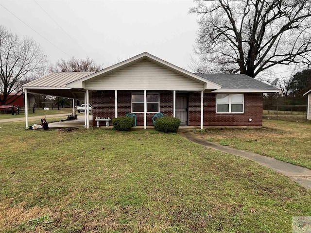 view of front of house with a front yard, an attached carport, and brick siding