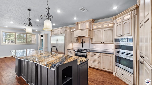 588 B K Pickering Dr, Texarkana, TX 75501 - kitchen with appliances with stainless steel finishes, a center island with sink, recessed lighting, dark wood finished floors, and tasteful backsplash