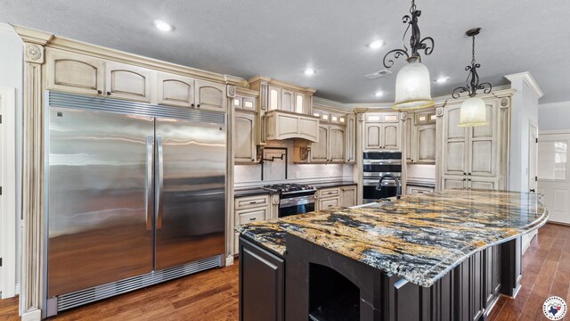588 B K Pickering Dr, Texarkana, TX 75501 - kitchen featuring appliances with stainless steel finishes, cream cabinets, crown molding, dark wood-type flooring, and recessed lighting