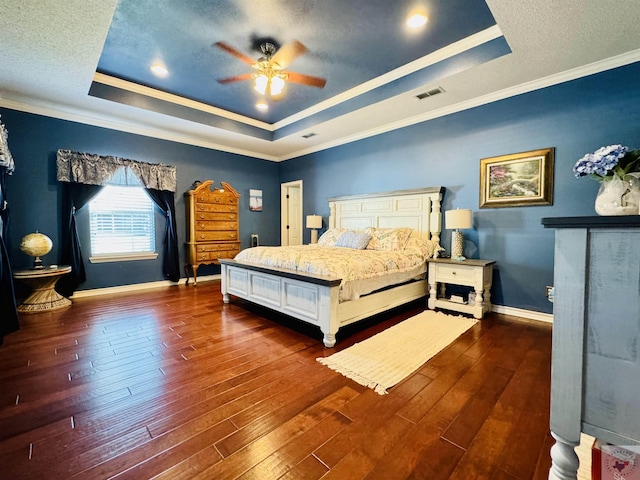 bedroom featuring ceiling fan, dark wood-type flooring, ornamental molding, and a raised ceiling