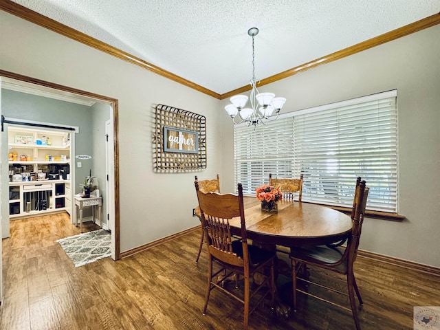 dining room featuring a chandelier, hardwood / wood-style floors, a textured ceiling, and crown molding