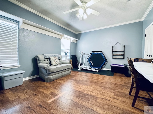 interior space featuring hardwood / wood-style flooring, a textured ceiling, ceiling fan, and ornamental molding