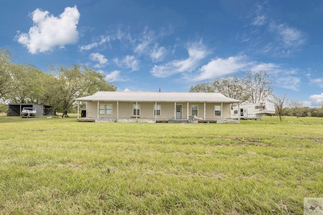 back of property featuring covered porch and a lawn