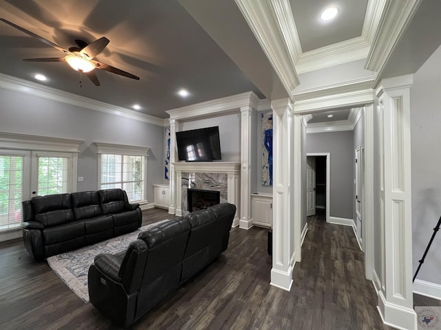 living room with a fireplace, decorative columns, dark wood-type flooring, and ornamental molding