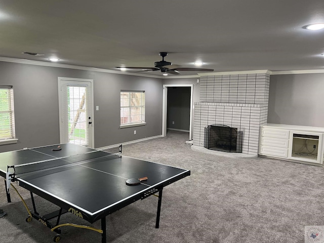 game room featuring carpet floors, crown molding, ceiling fan, and a fireplace