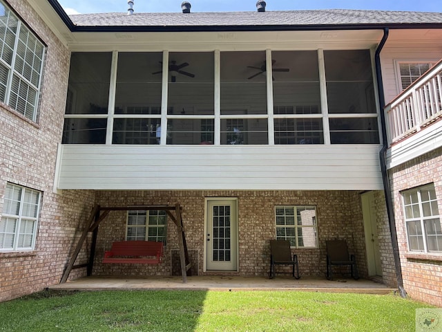 back of property featuring ceiling fan, a patio, a lawn, and a sunroom