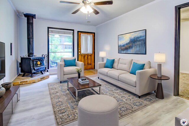 417 Carroll Ave, Wake Village, TX 75501 - unfurnished living room with a wood stove, crown molding, a ceiling fan, and wood finished floors