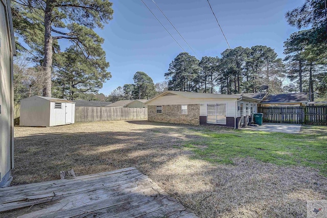 view of yard featuring an outbuilding, a shed, a patio, and a fenced backyard