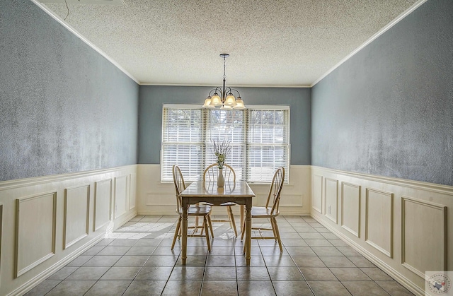 unfurnished dining area featuring tile patterned floors, a notable chandelier, crown molding, and a textured ceiling