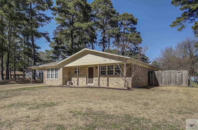 ranch-style home with a front yard, a porch, fence, and brick siding