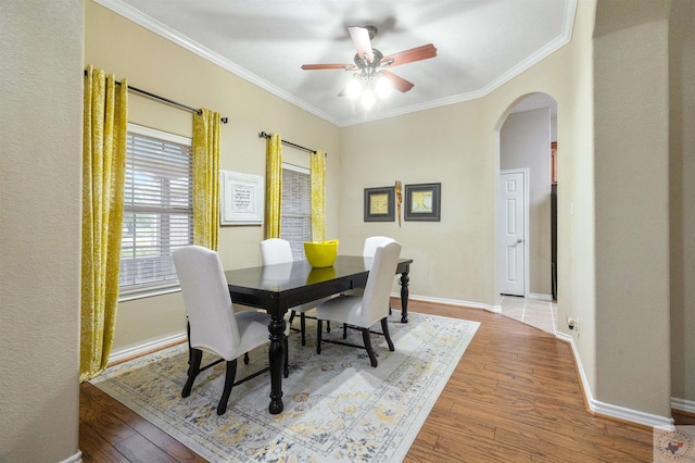 dining area with wood-type flooring, ceiling fan, and ornamental molding