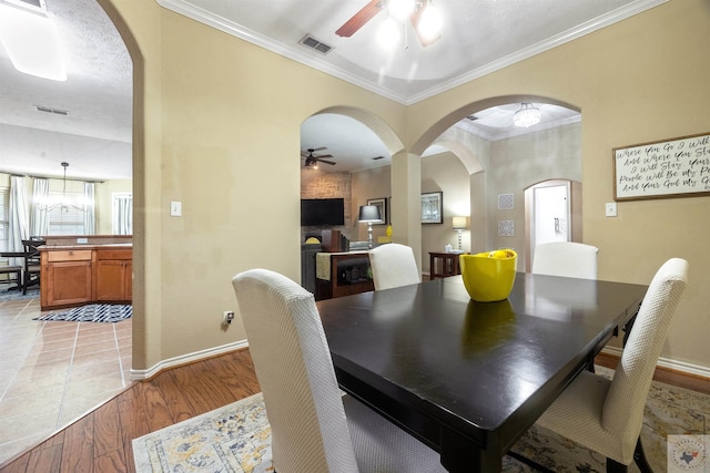 dining space featuring light hardwood / wood-style floors, ornamental molding, and ceiling fan