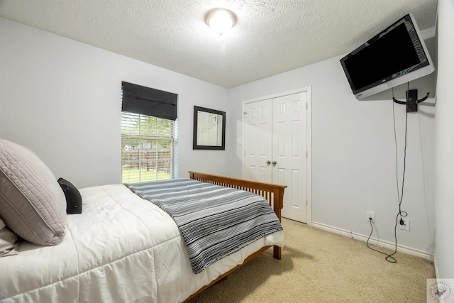 carpeted bedroom with a textured ceiling and a closet