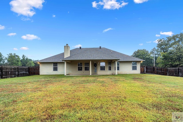 rear view of house featuring a lawn