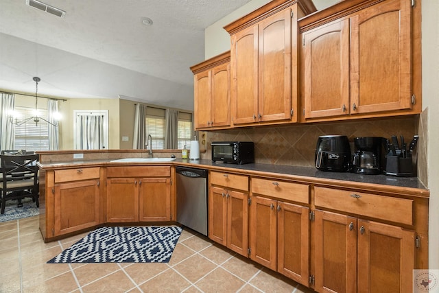 kitchen featuring pendant lighting, dishwasher, sink, backsplash, and kitchen peninsula