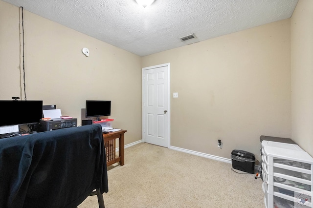 office area featuring light colored carpet and a textured ceiling