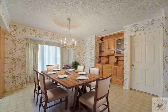 dining space featuring crown molding, an inviting chandelier, and a textured ceiling