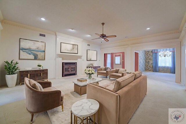 carpeted living room featuring ceiling fan with notable chandelier and ornamental molding