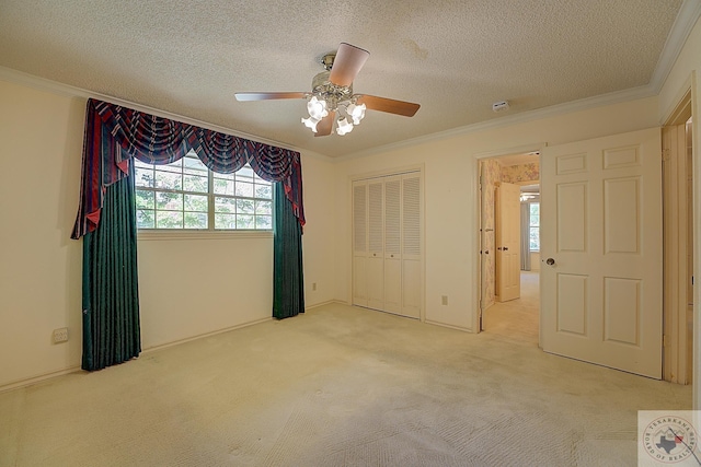 unfurnished bedroom featuring crown molding, ceiling fan, carpet flooring, a textured ceiling, and a closet