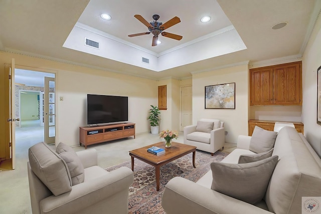 carpeted living room featuring ceiling fan, crown molding, and a tray ceiling