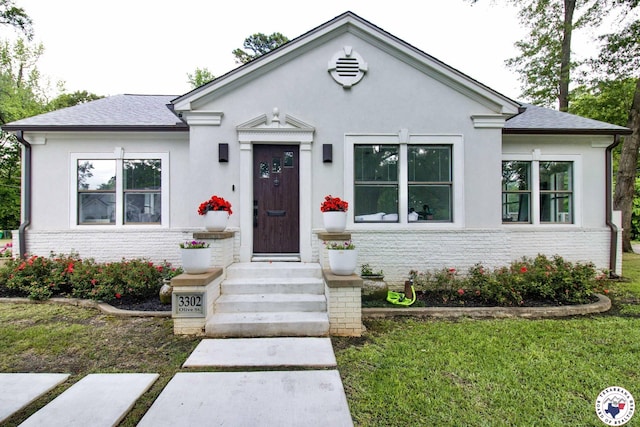3302 Olive St, Texarkana, TX 75503 - view of front of home with stucco siding, a front lawn, and a shingled roof