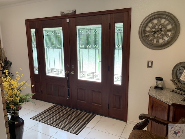 entrance foyer featuring ornamental molding and french doors