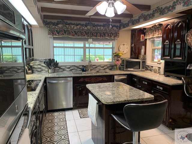 kitchen with tasteful backsplash, stainless steel appliances, a breakfast bar area, and a kitchen island