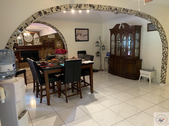 dining area with a fireplace and ornamental molding