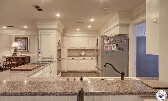 6 High Point Dr, Texarkana, TX 75503 - kitchen with appliances with stainless steel finishes, white cabinets, ornamental molding, dark stone countertops, and recessed lighting