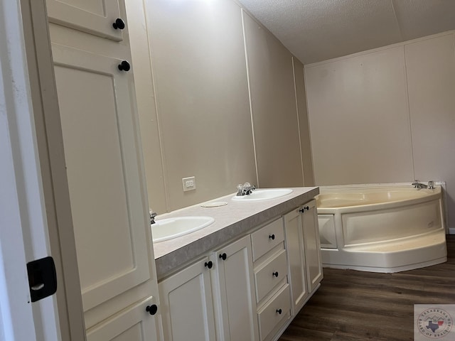 119 Krobot Cir, Texarkana, TX 75503 - bathroom with vanity, hardwood / wood-style flooring, a textured ceiling, and a bathing tub