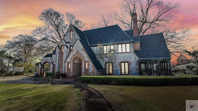 tudor home featuring a lawn