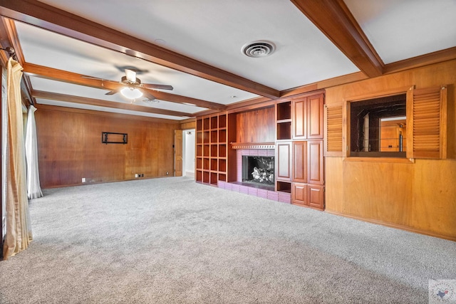 unfurnished living room featuring a fireplace, beam ceiling, and wooden walls