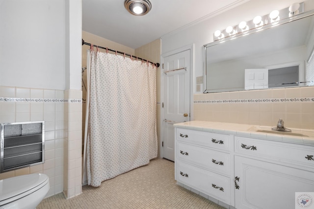 bathroom with vanity, toilet, walk in shower, and tile walls