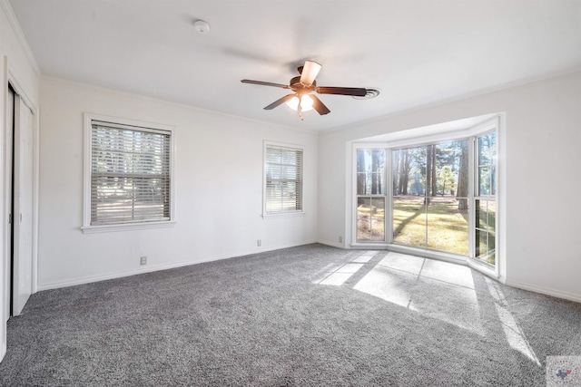 carpeted empty room with ceiling fan and crown molding