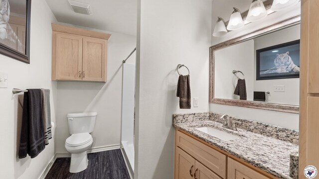 242 County Road 4228, Atlanta, TX 75551 - full bath with wood finished floors, toilet, vanity, and baseboards
