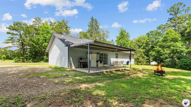 242 County Road 4228, Atlanta, TX 75551 - rear view of property featuring a fire pit, a patio, and a yard