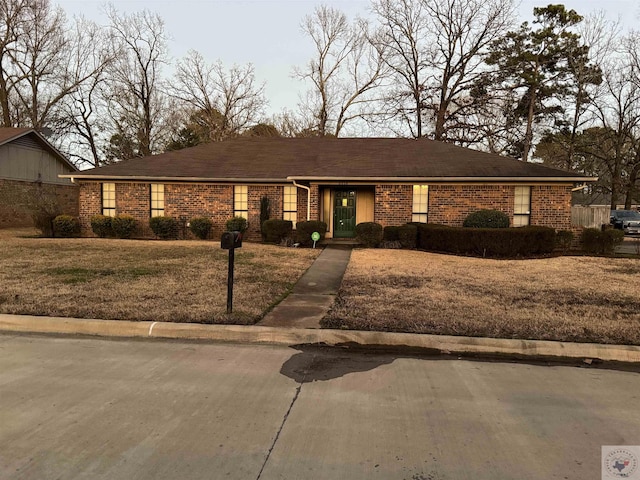 ranch-style home featuring a front yard and brick siding