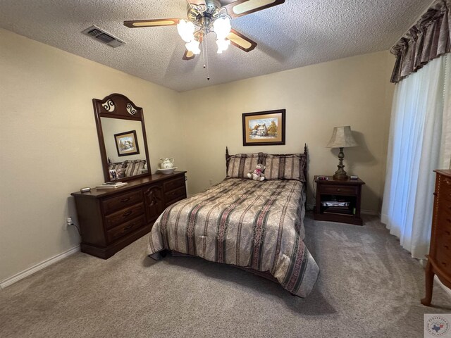 bedroom with baseboards, visible vents, a ceiling fan, a textured ceiling, and carpet floors