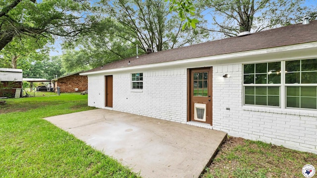 10 Vernon St, Hooks, TX 75561 - view of exterior entry featuring brick siding, a patio, and a lawn