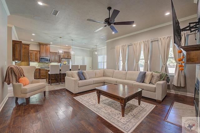 living room with ceiling fan, dark wood-type flooring, a textured ceiling, and ornamental molding