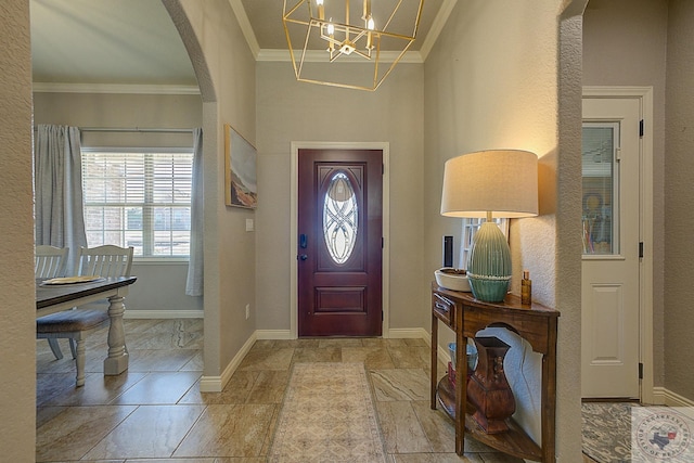 entryway featuring crown molding and an inviting chandelier