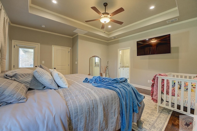 bedroom featuring ceiling fan, ornamental molding, dark wood-type flooring, and a tray ceiling