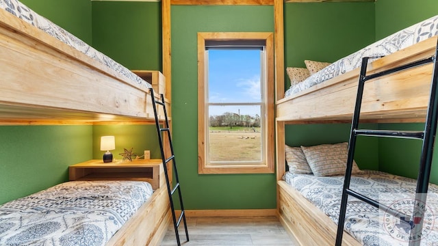 bedroom featuring baseboards and wood finished floors